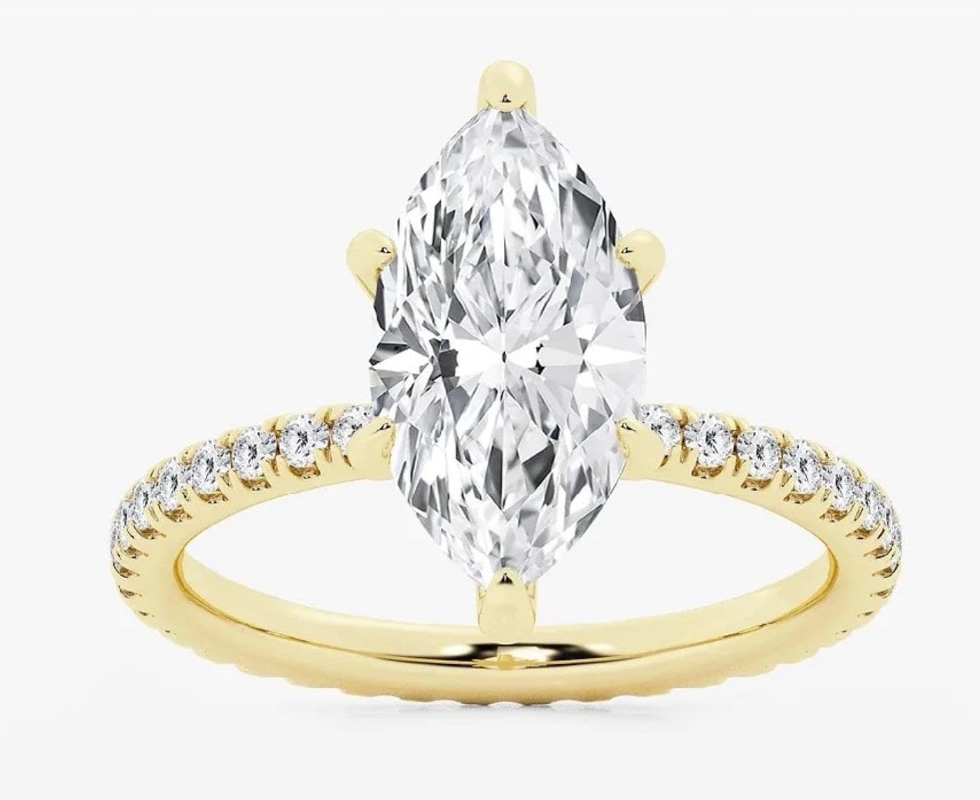 A marquise diamond ring in yellow gold with a pavé band